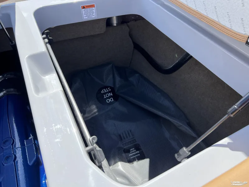 Slide: The Image of Open storage compartment in 2025 MasterCraft NXT24 boat, featuring "Do Not Step" warning. - 15