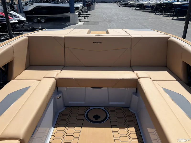 Slide: The Image of 2025 MasterCraft NXT24 boat interior with tan seating and hexagonal patterned flooring. - 7