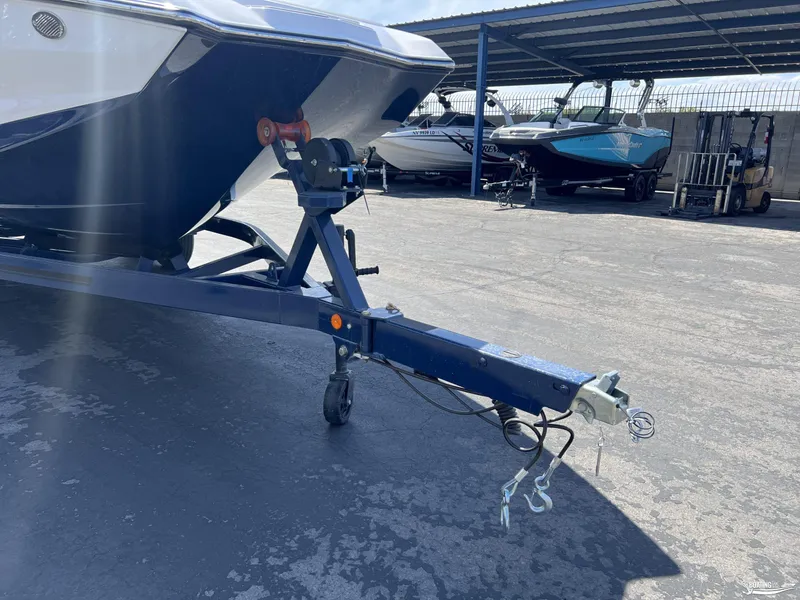 Slide: The Image of 2025 MasterCraft NXT22 boat on trailer in a covered storage area. - 20