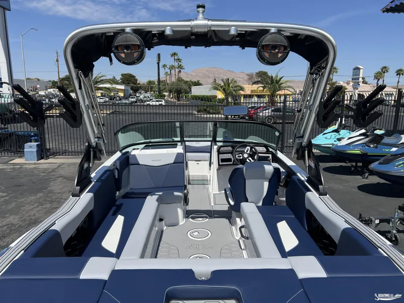 Slide: The Image of 2025 MasterCraft NXT22 boat interior with blue and white seating, parked outdoors. - 4