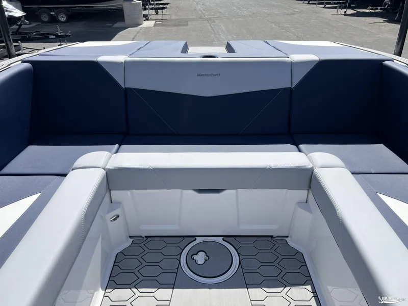 Slide: The Image of 2025 MasterCraft NXT22 boat interior with blue and gray seating, hexagonal floor design. - 7