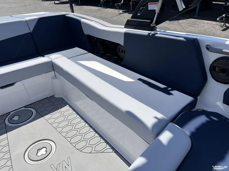 Slide: The Image of 2025 MasterCraft NXT22 boat interior with blue and gray seating, hexagonal floor pattern. - 8