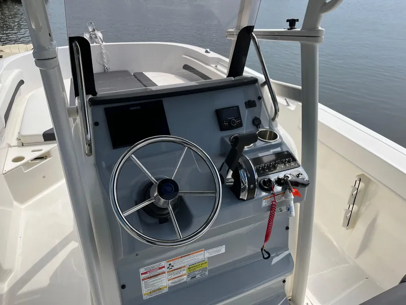 Slide: The Image of 2023 Bayliner Trophy T22CC boat console with steering wheel and controls. - 1
