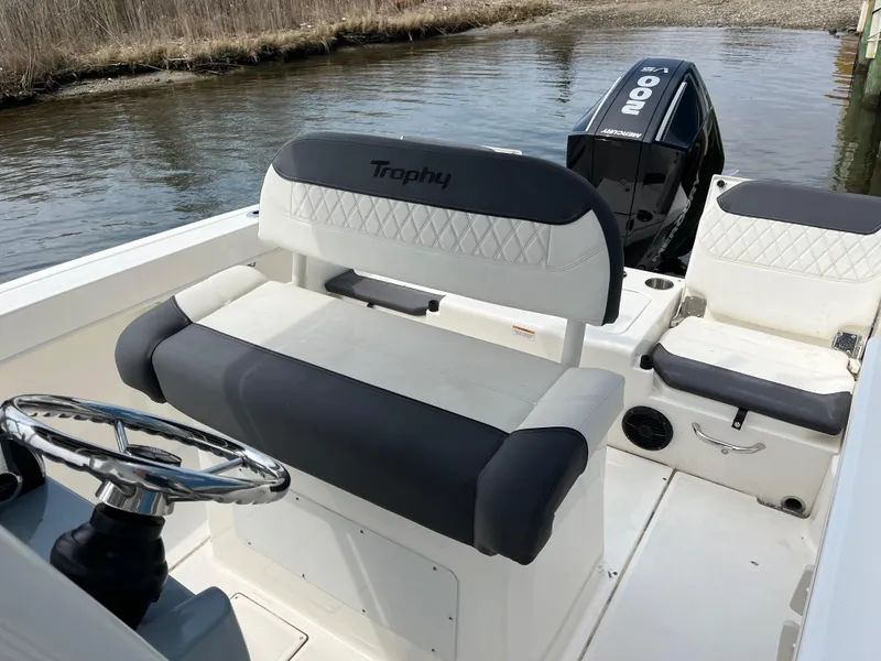 Slide: The Image of 2023 Bayliner Trophy T22CC boat interior with steering wheel and seating. - 2