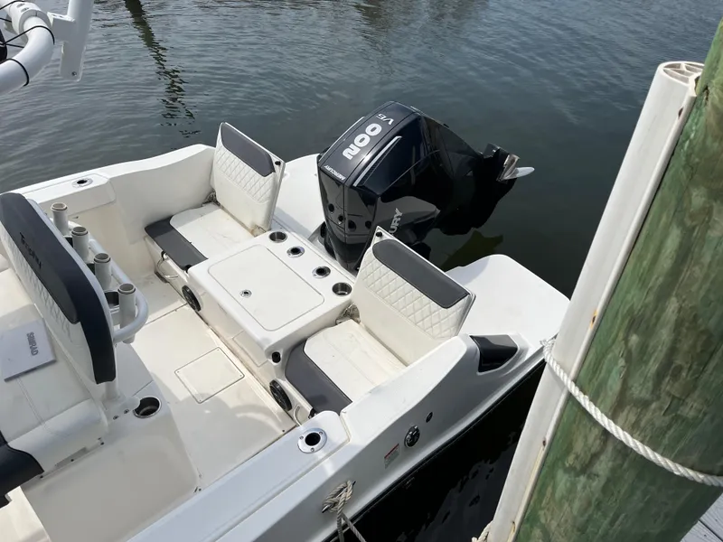 Slide: The Image of 2023 Bayliner Trophy T22CC boat with outboard motor, docked on calm water. - 9