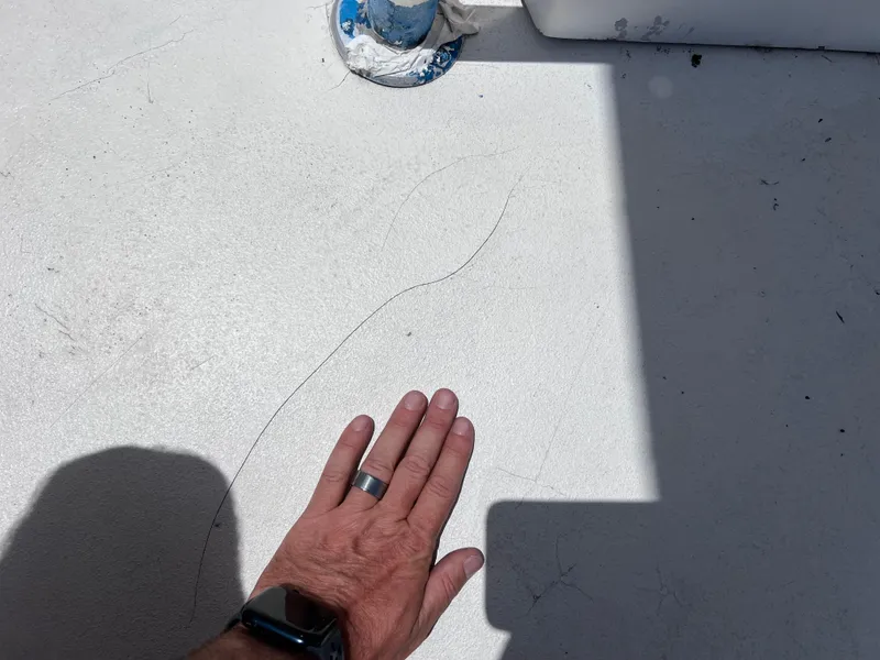 Slide: The Image of Hand inspecting surface crack on 2005 Twin Vee 22 Awesome Center Console boat deck. - 18