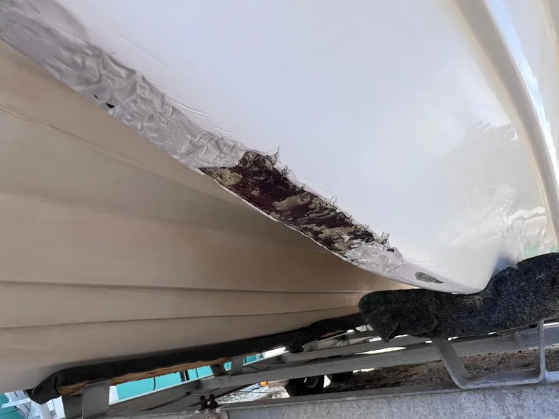 Slide: The Image of Damaged hull of 2005 Twin Vee 22 Center Console boat on trailer. - 19