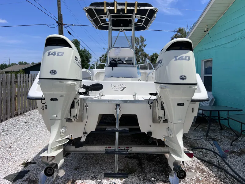 Slide: The Image of Twin Vee 22 Center Console boat with dual Suzuki 140 engines, parked on gravel. - 3