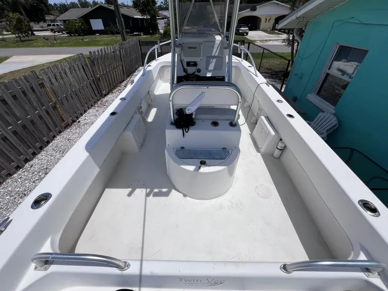 Slide: The Image of Twin Vee 22 Center Console boat, spacious deck, white interior, residential background. - 8