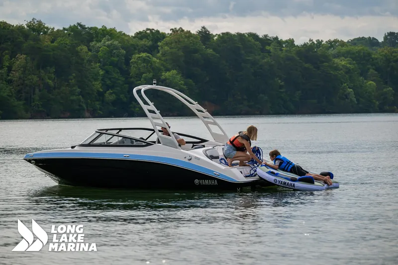 Slide: The Image of 2025 Yamaha Boats 195S on lake, people enjoying water activities, Long Lake Marina. - 4