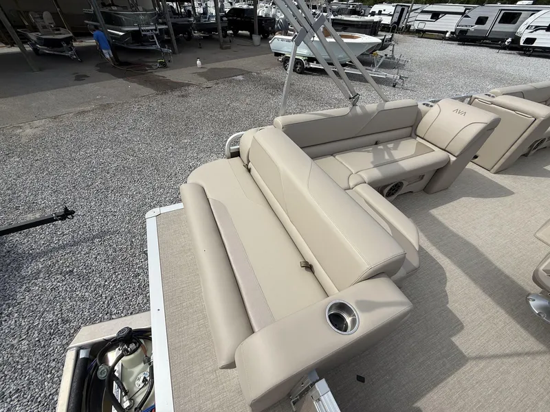 Slide: The Image of 2025 Avalon Venture 21 CRUISE boat with beige seating and cup holders, parked on gravel. - 6