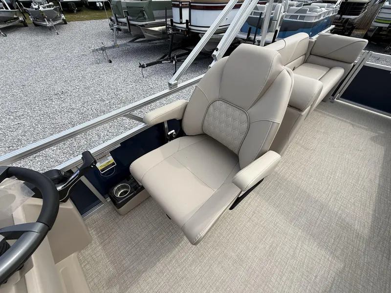 Slide: The Image of 2025 Avalon VENTURE 23 QUAD LOUNGER boat interior with plush seating and steering wheel. - 10