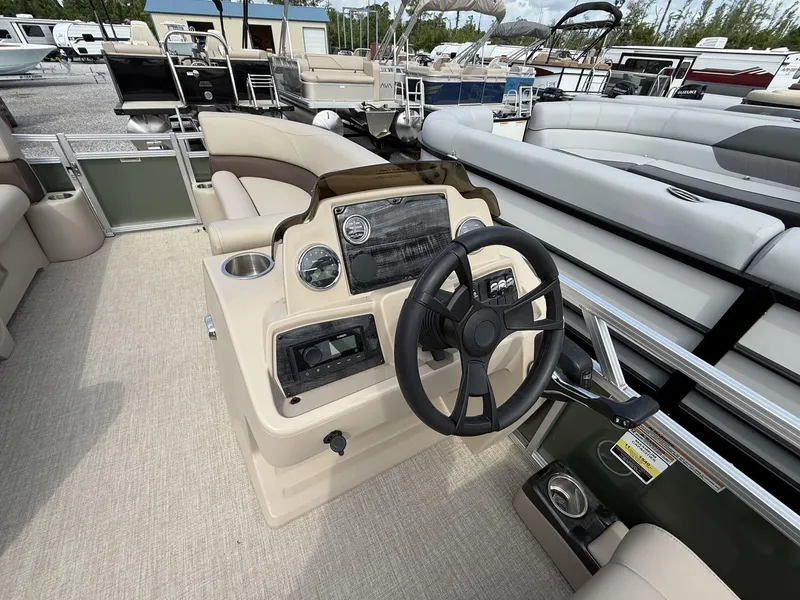 Slide: The Image of 2025 Avalon VLS 23 Quad Lounger boat interior with steering wheel and seating area. - 6