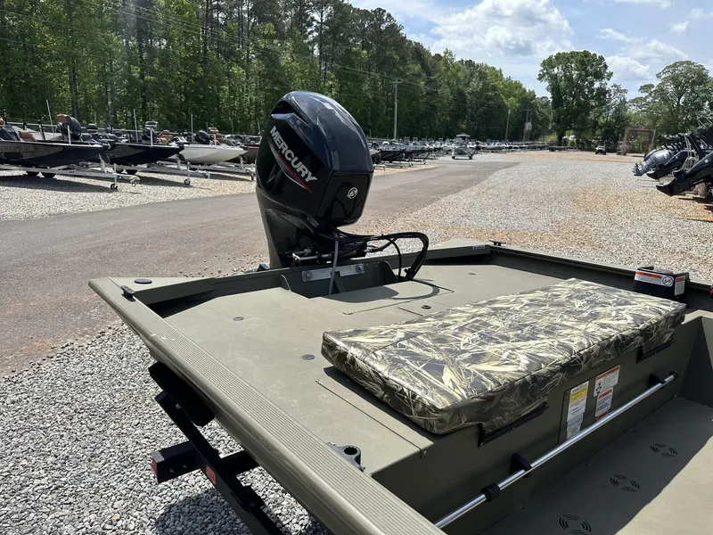 Slide: The Image of 2024 Tracker Grizzly 1860 CC boat with Mercury engine, parked outdoors on gravel. - 3