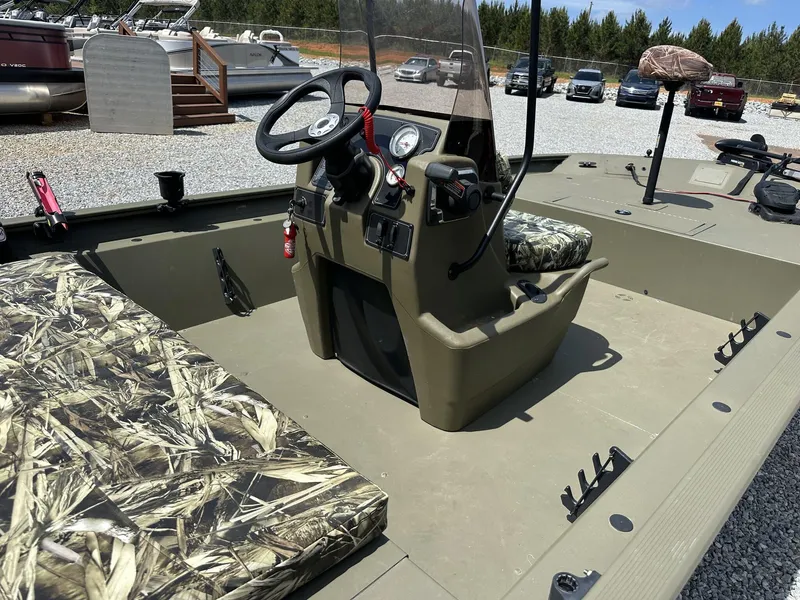 Slide: The Image of 2024 Tracker Grizzly 1860 CC boat interior with camouflage seating and steering console. - 6