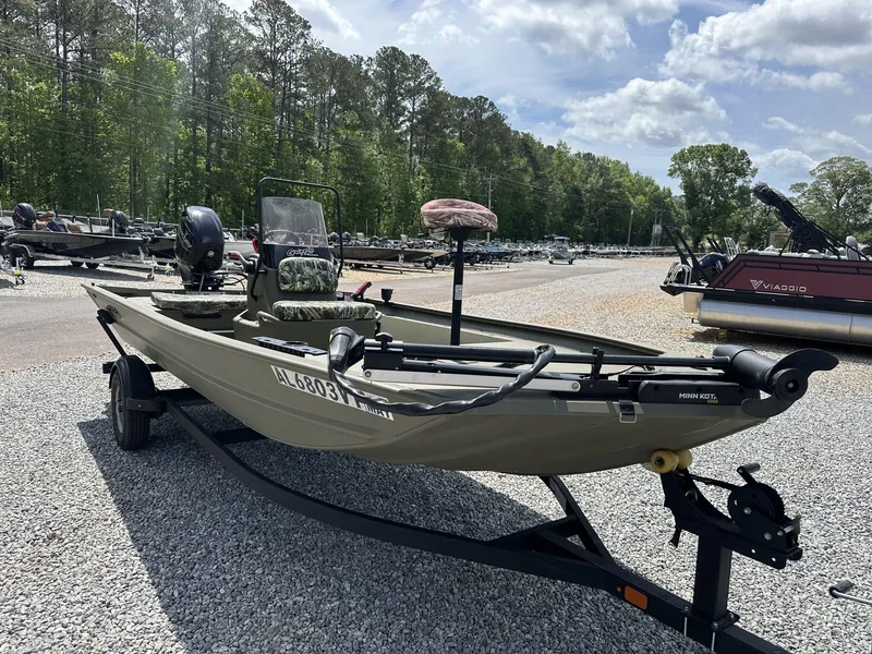 Slide: The Image of 2024 Tracker Grizzly 1860 CC boat on trailer, parked outdoors on gravel. - 9