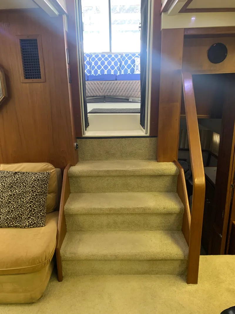 Slide: The Image of 1994 Carver 440 Aft Cabin Motor Yacht interior with stairs, seating, and kitchen area. - 10