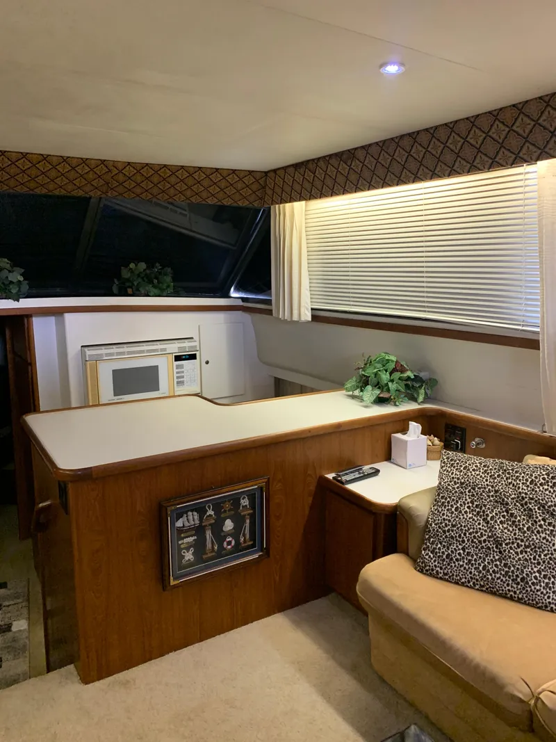 Slide: The Image of Interior of 1994 Carver 440 Aft Cabin Motor Yacht with cozy seating and kitchenette. - 14