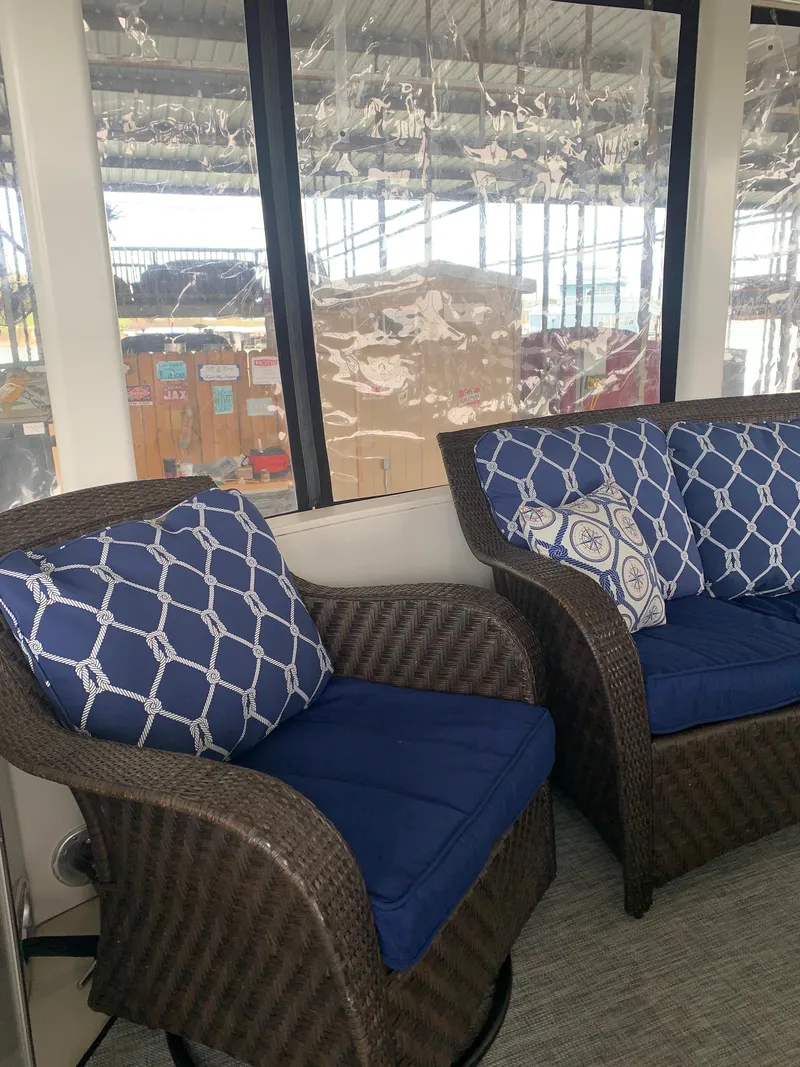 Slide: The Image of 1994 Carver 440 Aft Cabin Motor Yacht interior with blue cushioned wicker chairs. - 18