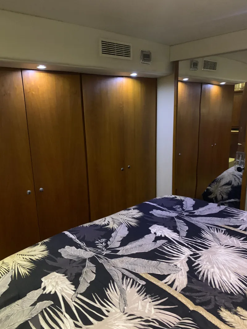 Slide: The Image of Bedroom interior of 1994 Carver 440 Aft Cabin Motor Yacht with wooden closets and patterned bedding. - 22
