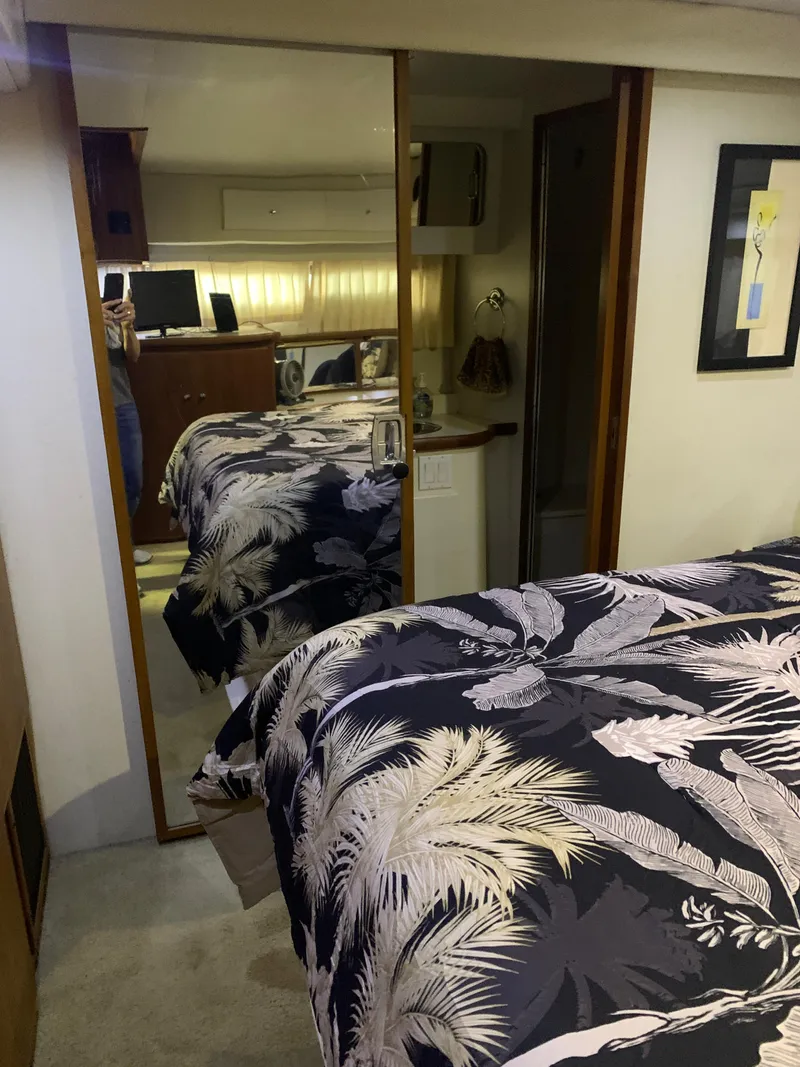 Slide: The Image of Interior of 1994 Carver 440 Aft Cabin Motor Yacht with mirrored closet and patterned bedding. - 23