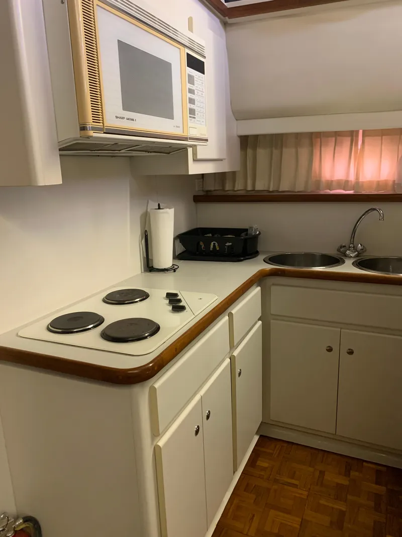 Slide: The Image of Compact kitchen in 1994 Carver 440 Aft Cabin Motor Yacht with stove, microwave, and sink. - 30