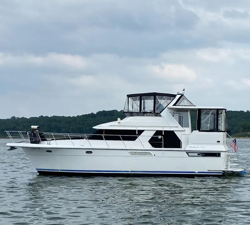 The Image of 1994 Carver 440 Aft Cabin Motor Yacht on calm water, overcast sky. - 0