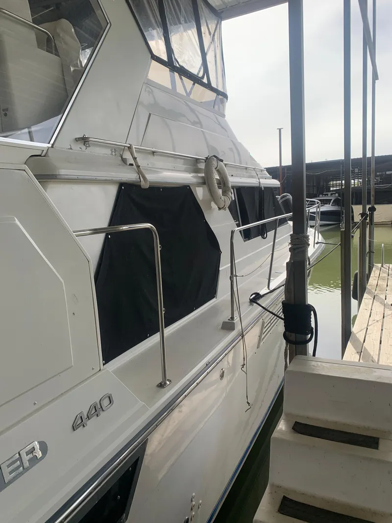 Slide: The Image of 1994 Carver 440 Aft Cabin Motor Yacht interior with TV and wooden cabinetry. - 11