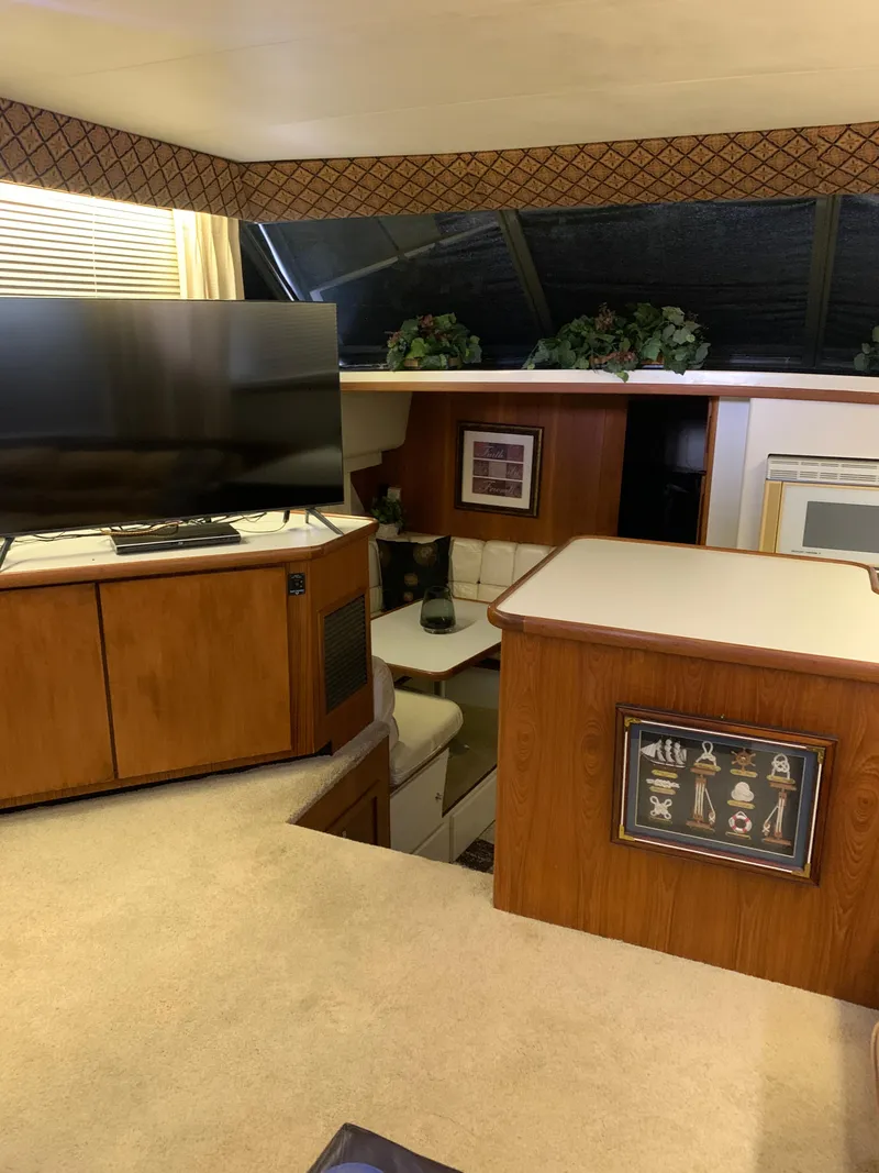 Slide: The Image of 1994 Carver 440 Aft Cabin Motor Yacht interior with covered seating and clear windows. - 13