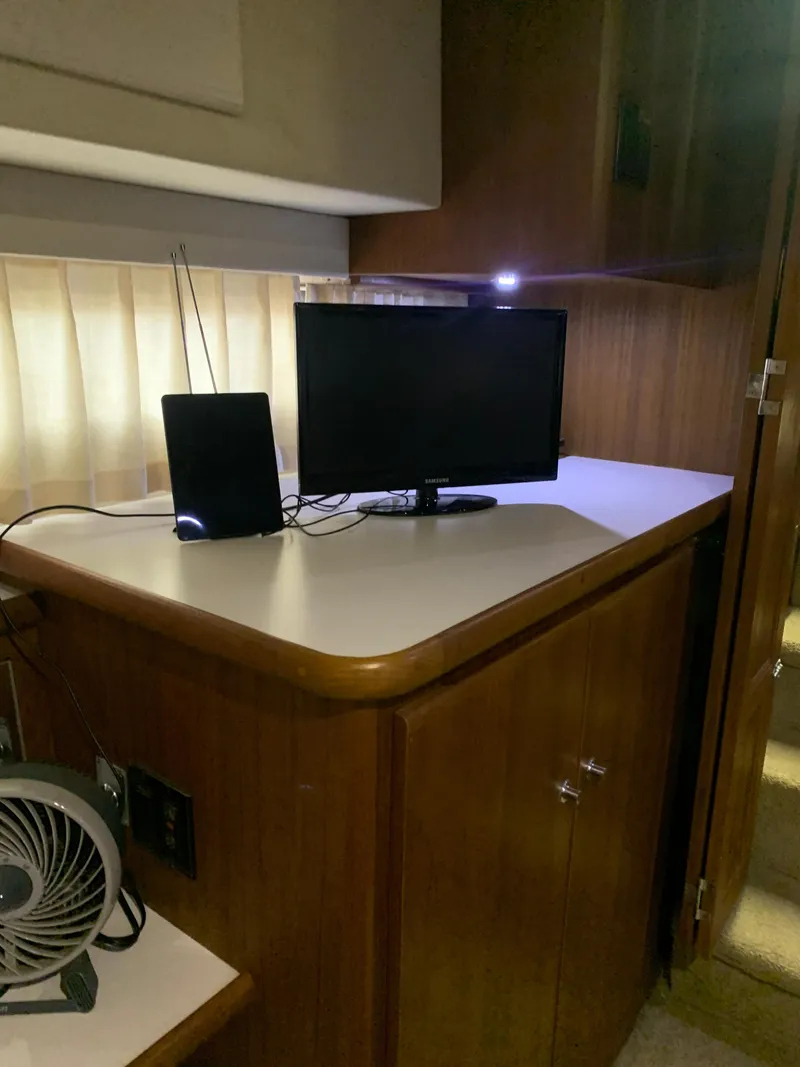Slide: The Image of Interior of 1994 Carver 440 Aft Cabin Motor Yacht with wood paneling and tropical bedding. - 21