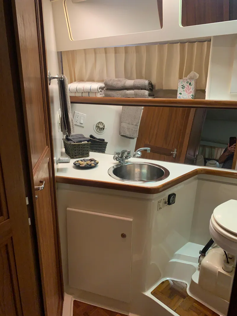 Slide: The Image of 1994 Carver 440 Aft Cabin Motor Yacht with American flag, docked in a marina. - 37