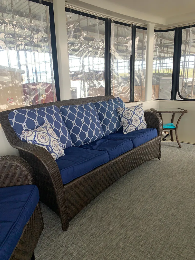 Slide: The Image of 1994 Carver 440 Aft Cabin Motor Yacht interior with blue cushioned seating and decorative pillows. - 46