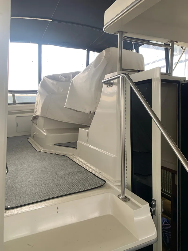 Slide: The Image of 1994 Carver 440 Aft Cabin Motor Yacht interior with covered seating and carpeted flooring. - 52