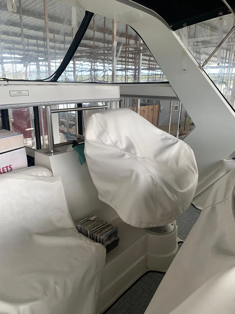 Slide: The Image of 1994 Carver 440 Aft Cabin Motor Yacht interior with covered seating and helm. - 55