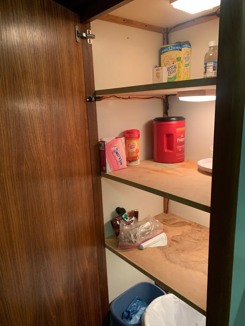 Slide: The Image of Wooden pantry shelves with various food items on a 1994 Carver 440 Aft Cabin Motor Yacht. - 69