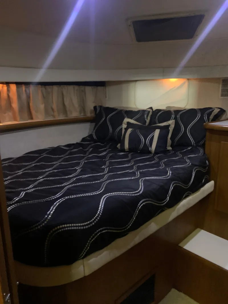 Slide: The Image of 1994 Carver 440 Aft Cabin Motor Yacht bedroom with black patterned bedding. - 71