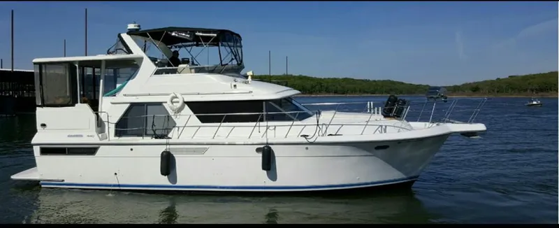 Slide: The Image of 1994 Carver 440 Aft Cabin Motor Yacht on calm water, side view. - 79