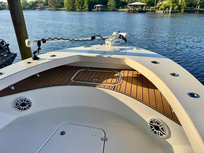 Slide: The Image of 2023 ZCB Freemason 26 boat deck with wood finish, on a serene lake. - 10