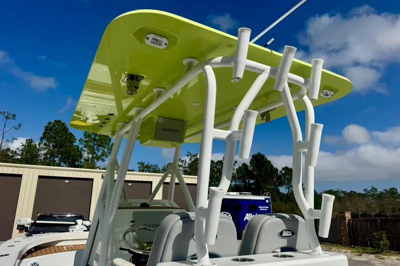 Slide: The Image of 2023 ZCB Freemason 26 boat with lime green canopy and rod holders, under a clear blue sky. - 11
