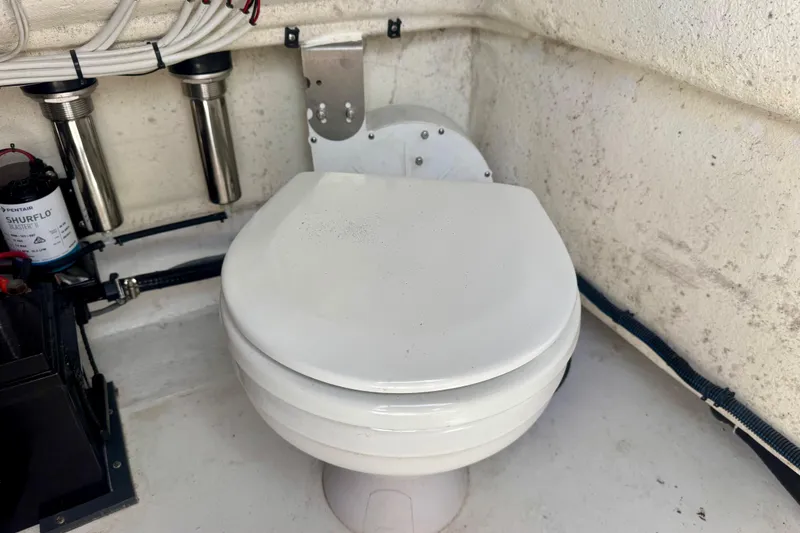 Slide: The Image of Marine toilet setup in a 2023 ZCB Freemason 26 boat, featuring plumbing and pump system. - 15