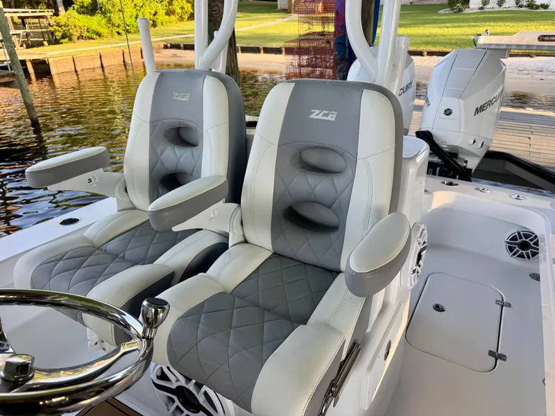 Slide: The Image of 2023 ZCB Freemason 26 boat seats with gray and white upholstery, dockside view. - 3