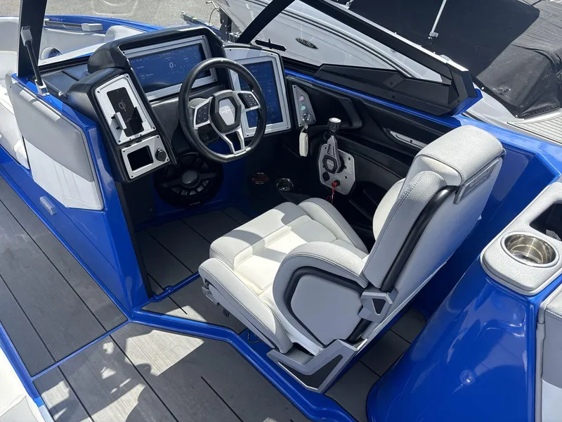 Slide: The Image of 2022 Supra SE 450 boat interior with modern dashboard and steering wheel, featuring blue and white design. - 11
