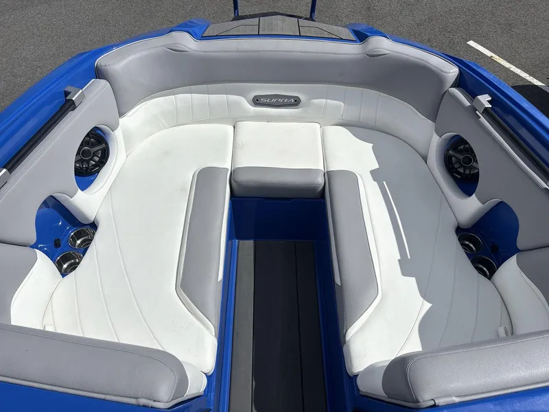 Slide: The Image of 2022 Supra SE 450 boat interior with white and gray seating, blue accents, and built-in speakers. - 7
