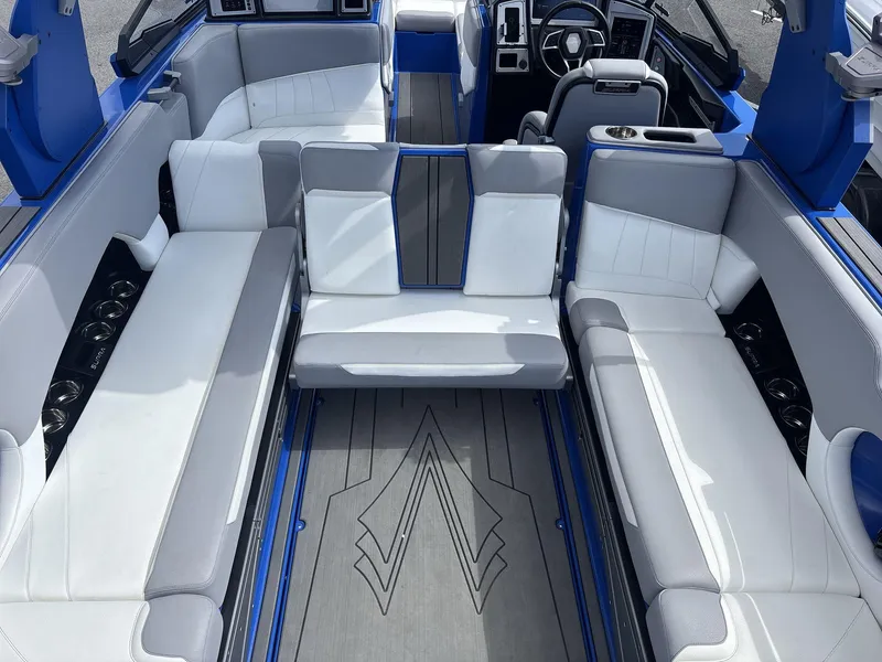 Slide: The Image of 2022 Supra SE 450 boat interior with white and gray seating, blue accents, and modern dashboard. - 9