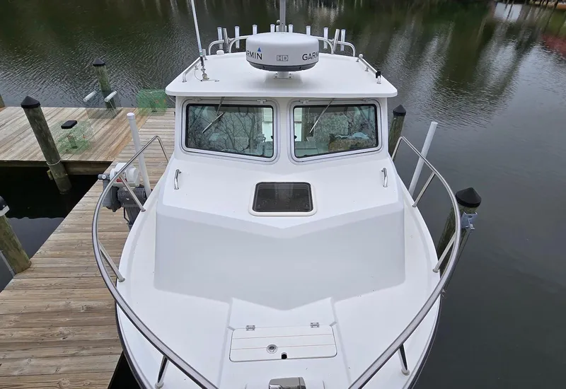Slide: The Image of 2014 Parker 2520 XLD Sport Cabin boat docked on calm water. - 15