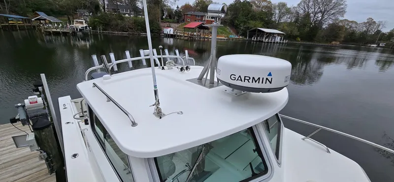 Slide: The Image of 2014 Parker 2520 XLD Sport Cabin boat with Garmin radar on a calm lake. - 16