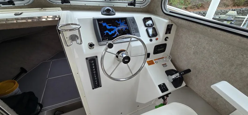 Slide: The Image of 2014 Parker 2520 XLD Sport Cabin helm with steering wheel and navigation display. - 6