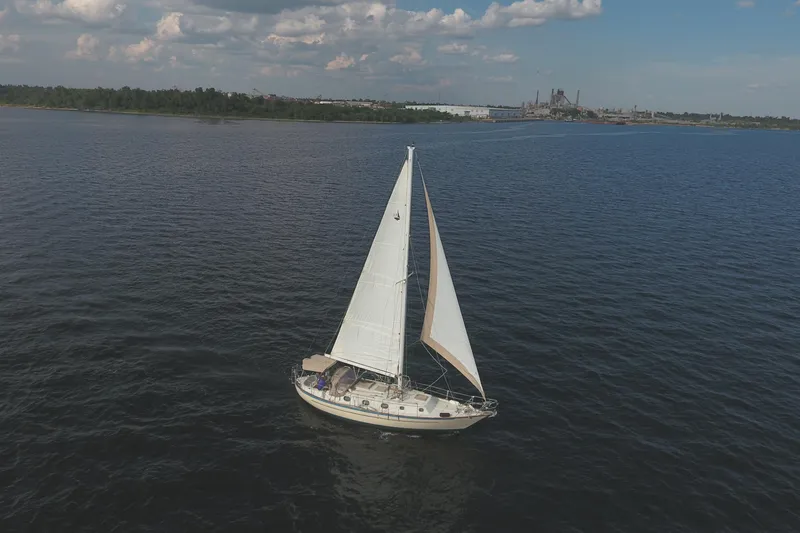Slide: The Image of 1986 Pacific Seacraft Crealock 37 sailboat on open water under a cloudy sky. - 2