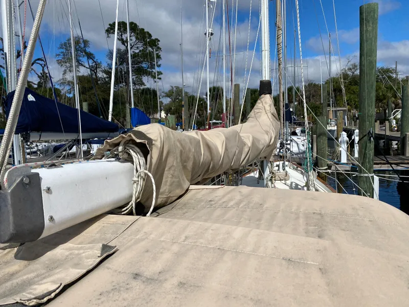 Slide: The Image of 1986 Pacific Seacraft Crealock 37 sailboat with covered boom in marina setting. - 21