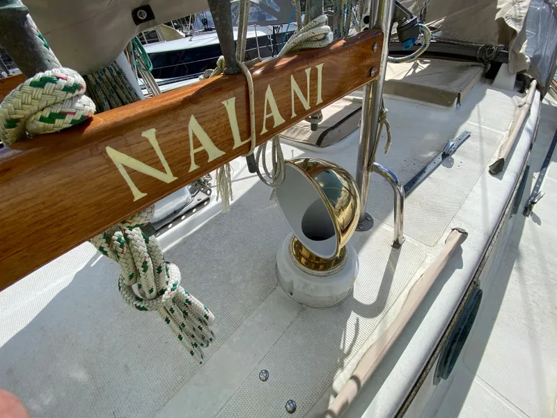 Slide: The Image of 1986 Pacific Seacraft Crealock 37 deck with ropes and brass vent, featuring "NALANI" nameplate. - 25